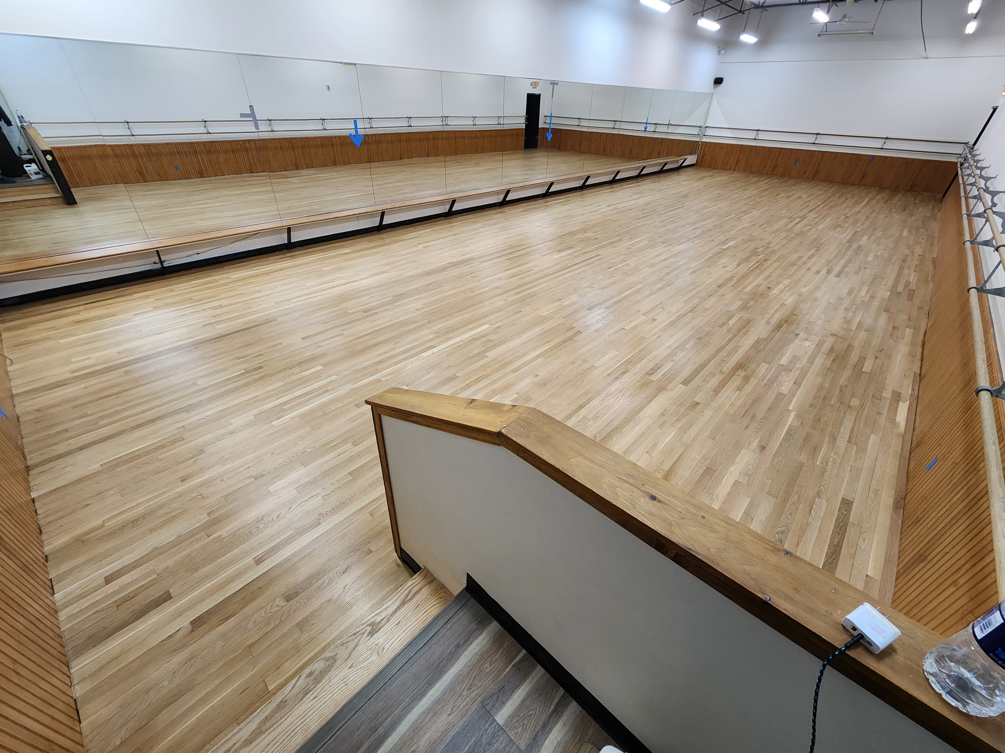 Large mirrored dance studio with a freshly refinished light hardwood floor