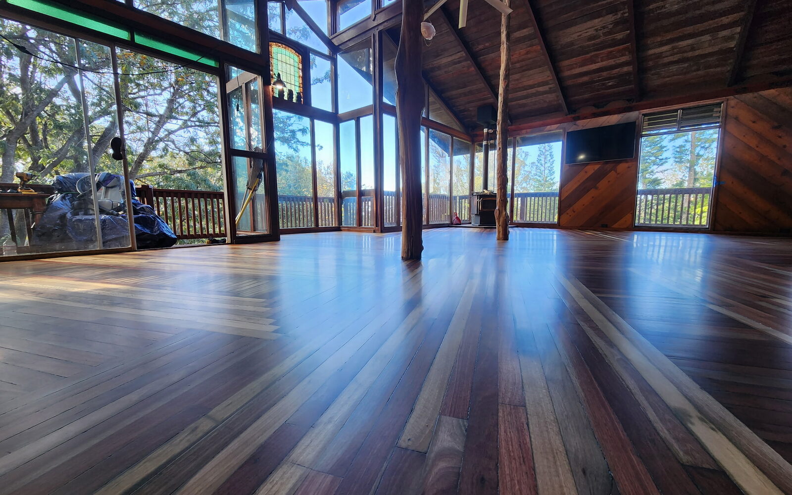 Refinished timber-frame great room with a rich, mirror-finish hardwood floor by Frederick Flooring and Refinishing