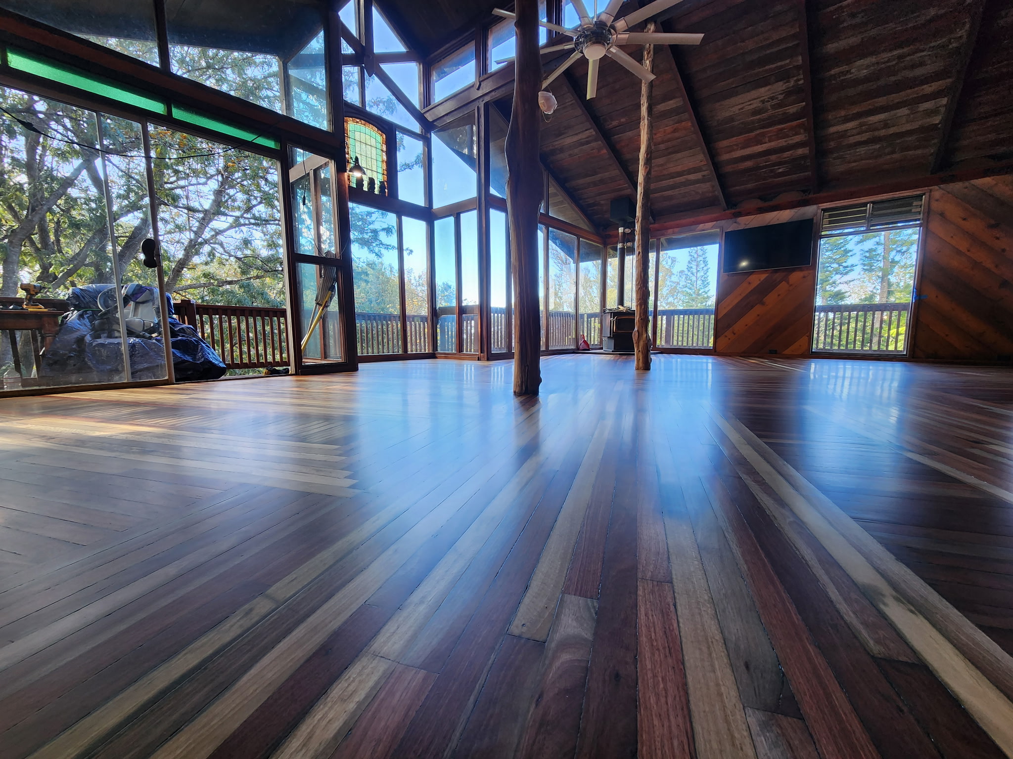 Finished timber-frame cabin floor restored to a rich, glossy hardwood finish